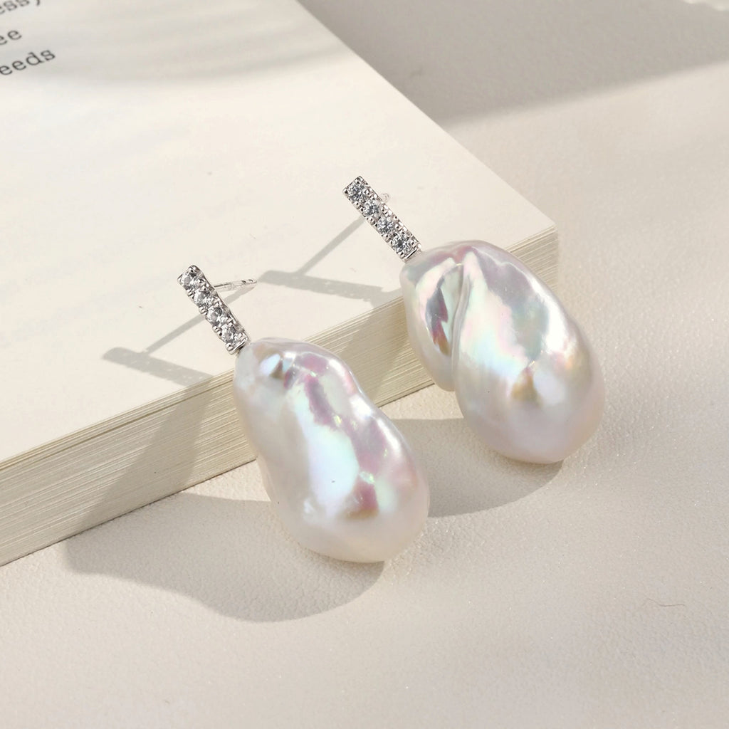 Detail view of baroque freshwater pearl cubic zirconia bar stud earrings in white gold color