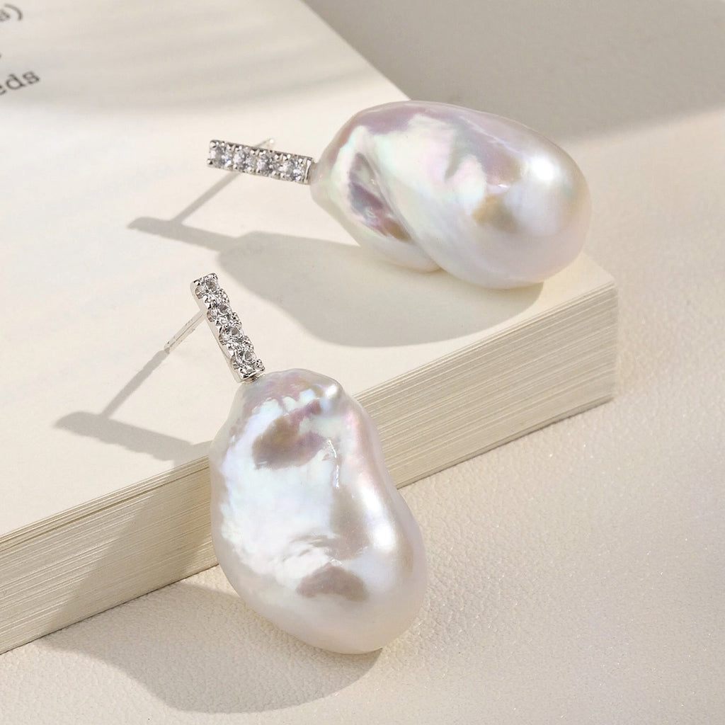 Close-up of baroque freshwater pearl cubic zirconia bar stud earrings in white gold color