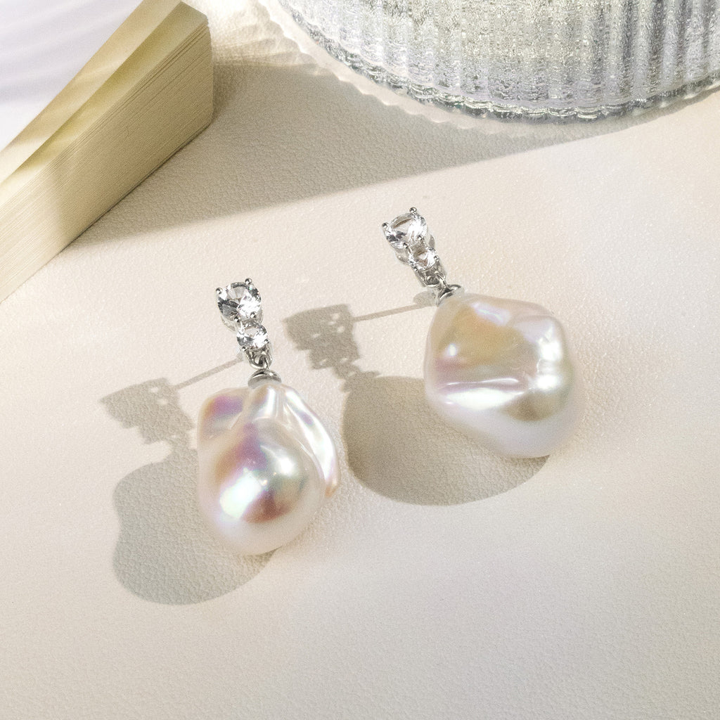 Detail view of baroque freshwater pearl double cubic zirconia stud earrings in white gold color