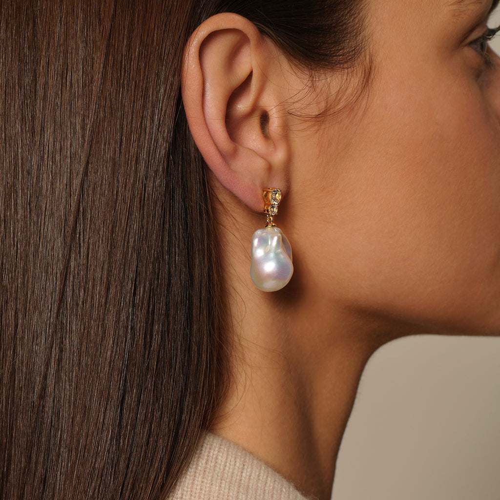 Model wearing baroque freshwater pearl double cubic zirconia stud earrings in yellow gold color, lifestyle view