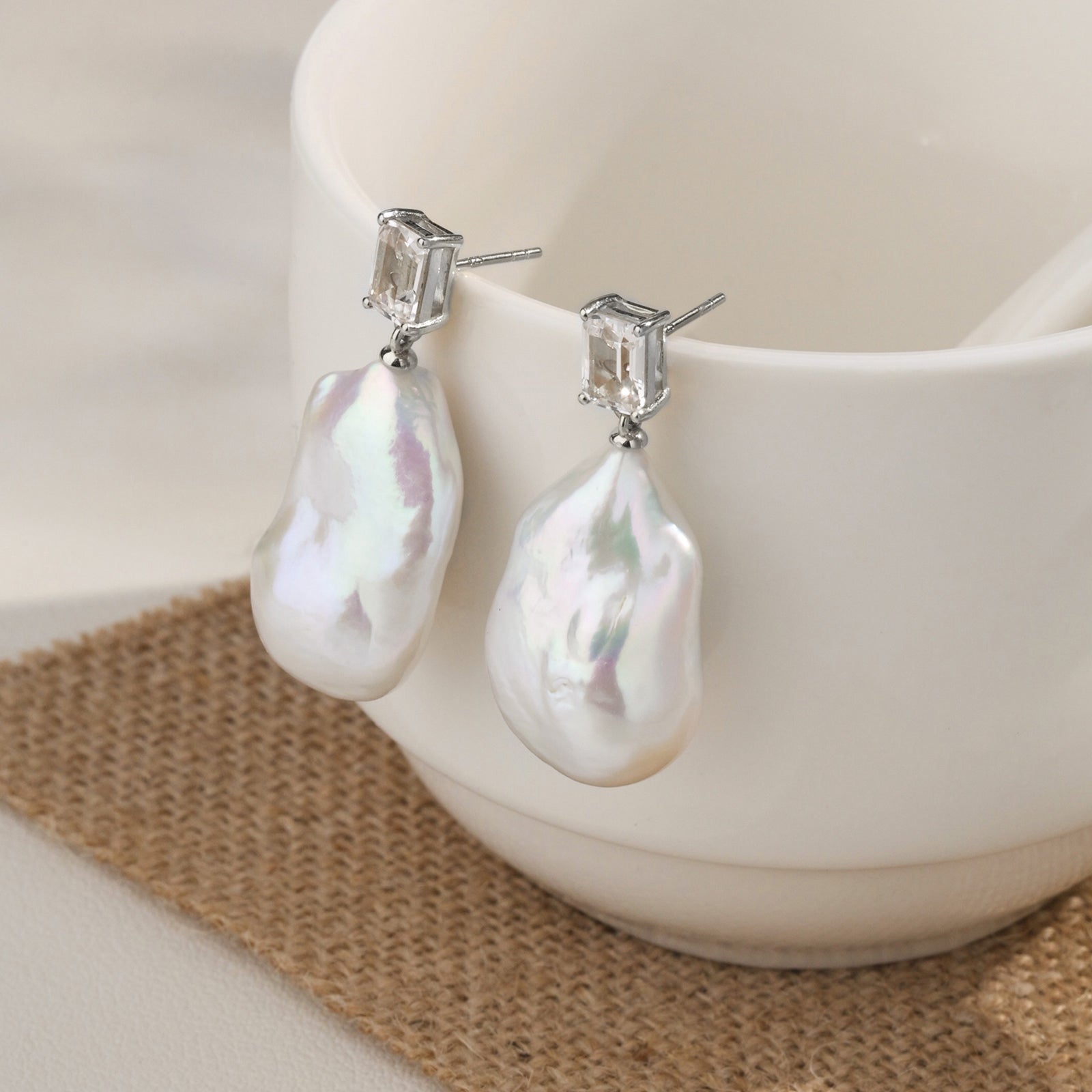 Model wearing baroque freshwater pearl rectangular cubic zirconia stud earrings in white gold color