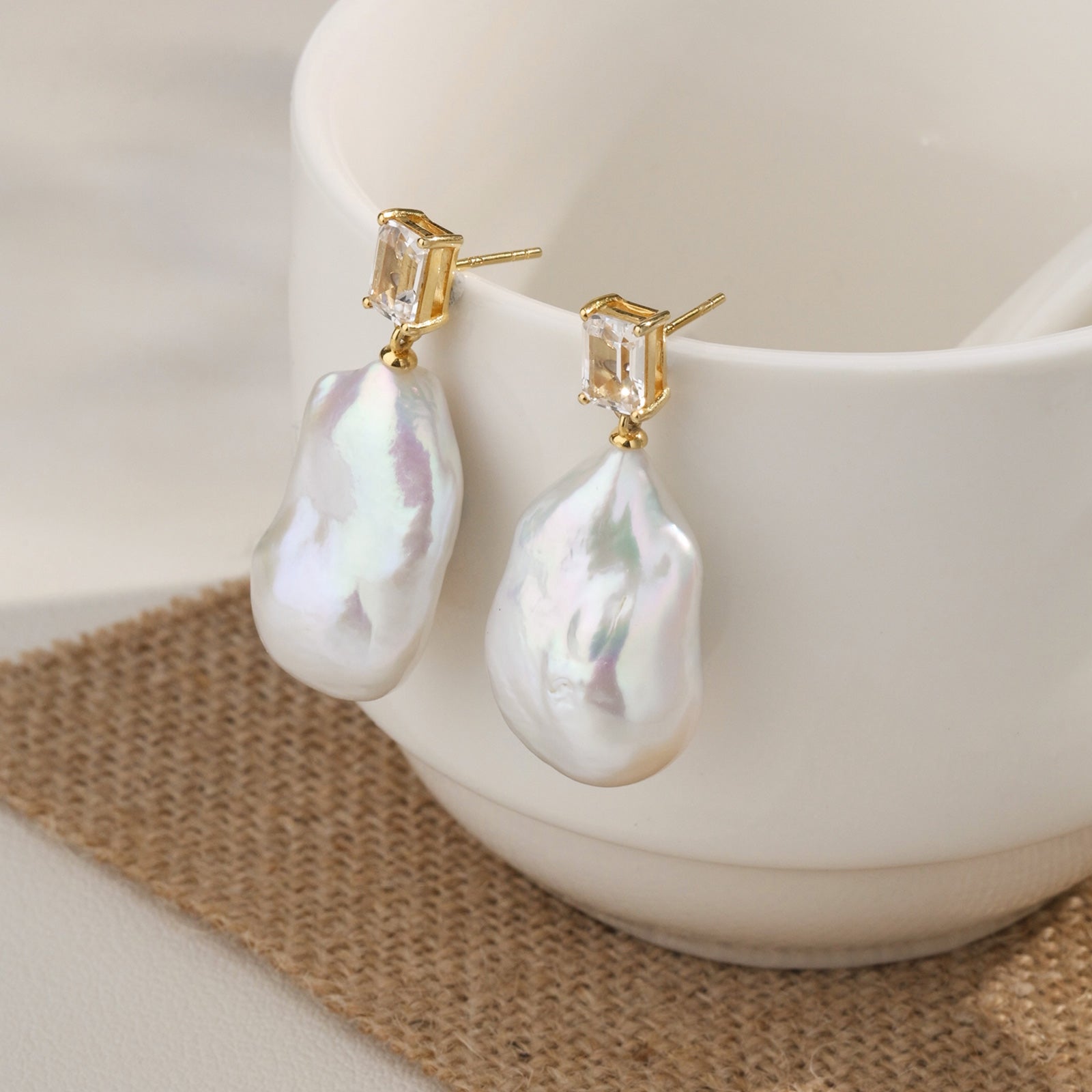 Model wearing baroque freshwater pearl rectangular cubic zirconia stud earrings in yellow gold color