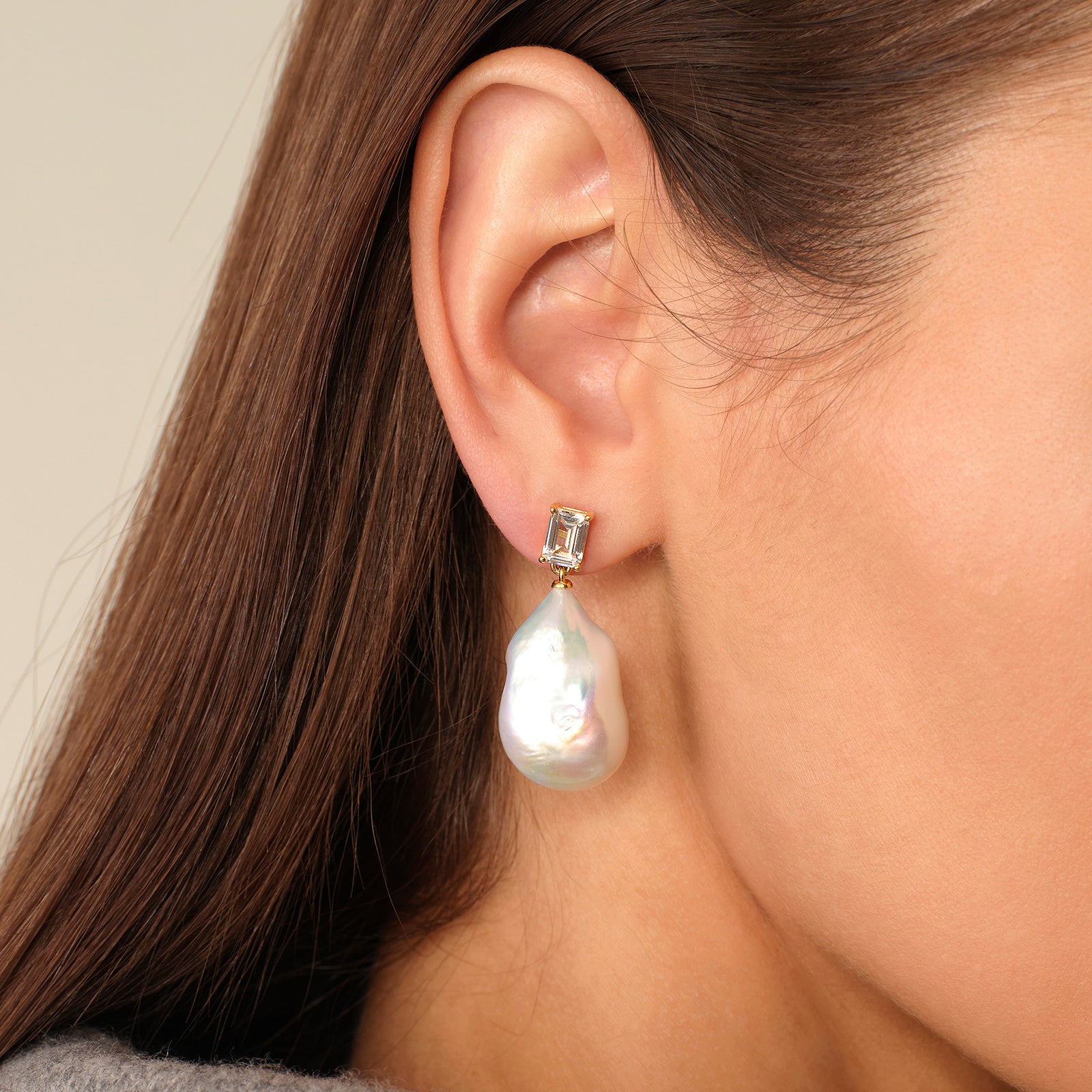 Close-up of model wearing baroque freshwater pearl rectangular cubic zirconia stud earrings in yellow gold color