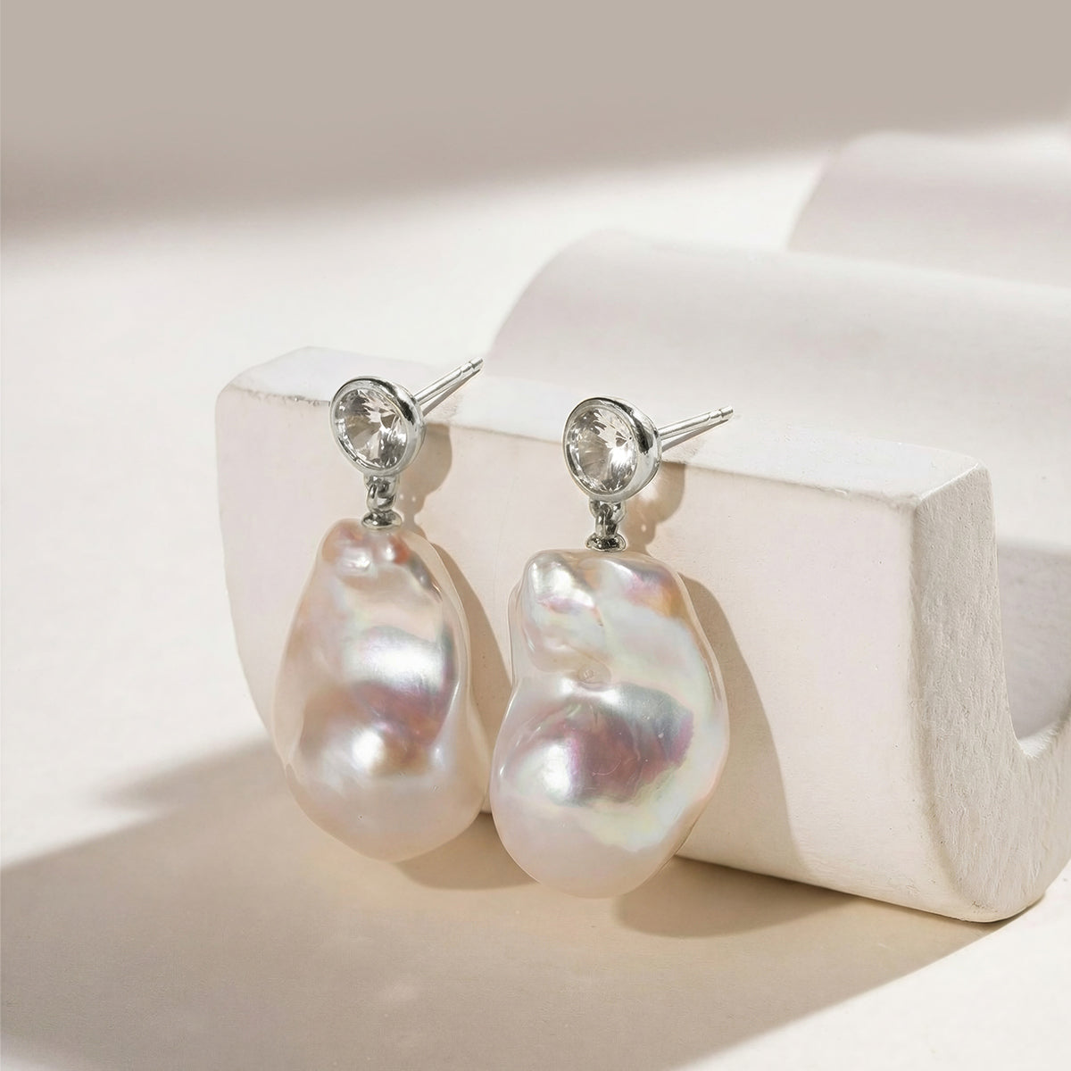 Detail view of baroque freshwater pearl round cubic zirconia stud earrings in white gold color