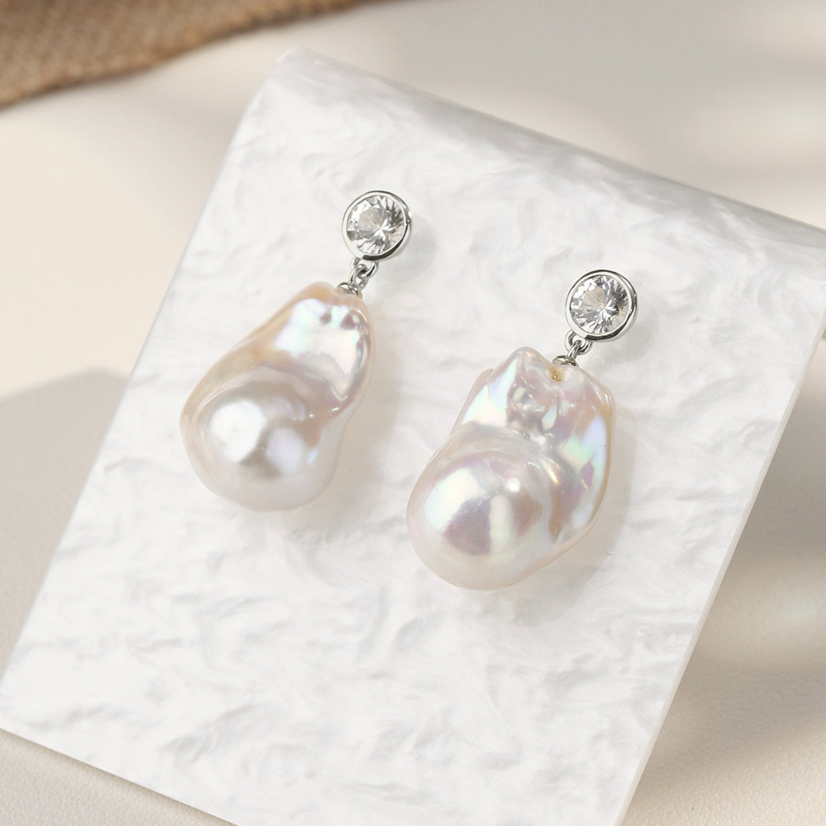 Close-up of baroque freshwater pearl round cubic zirconia stud earrings in white gold color