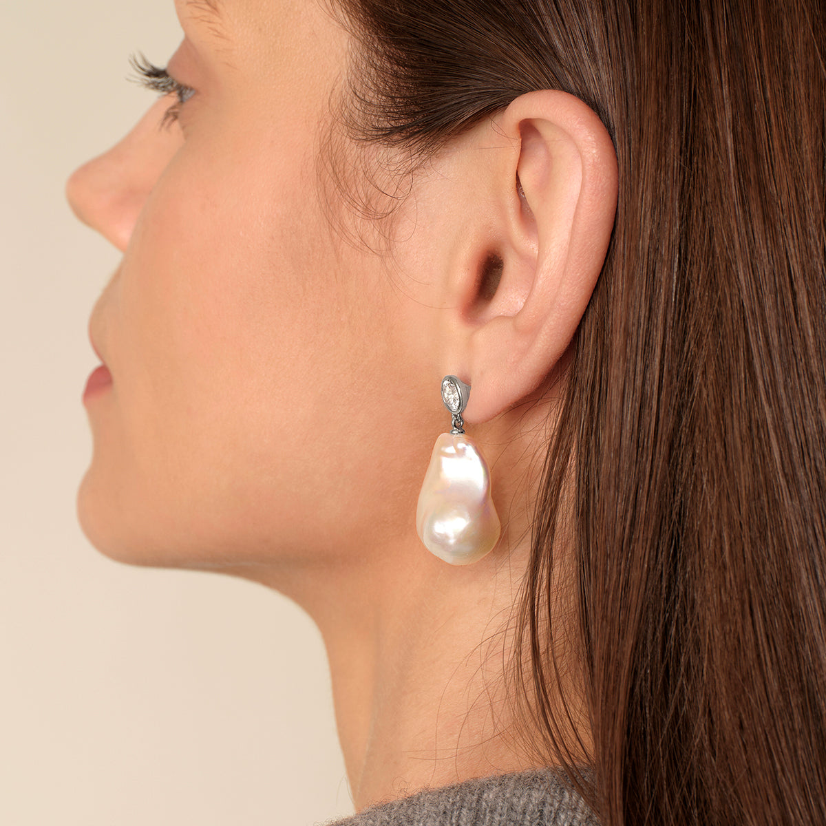 Model wearing baroque freshwater pearl round cubic zirconia stud earrings in white gold color, lifestyle view
