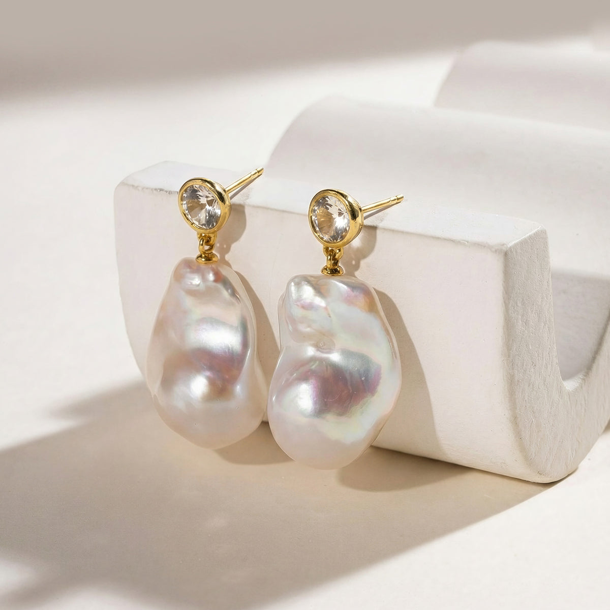 Close-up of baroque freshwater pearl round cubic zirconia stud earrings in yellow gold color