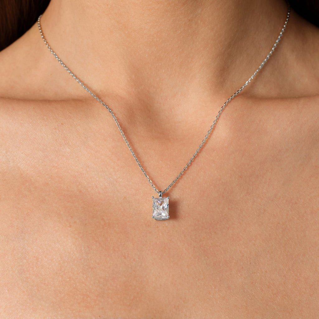 Model wearing emerald-cut cubic zirconia pendant necklace in white gold color