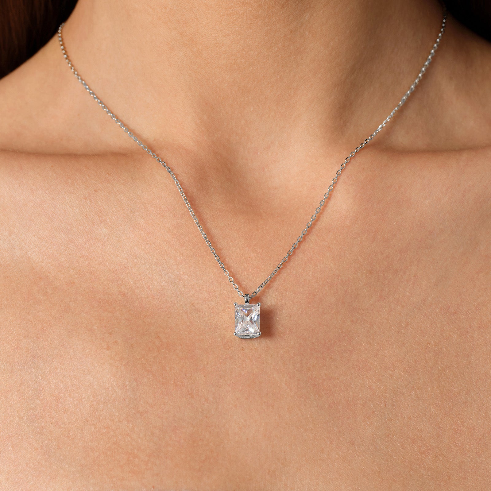 Model wearing emerald-cut cubic zirconia pendant necklace in white gold color