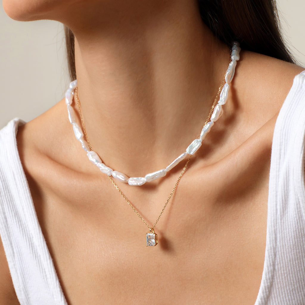 Model wearing emerald-cut cubic zirconia pendant necklace in yellow gold color, lifestyle view