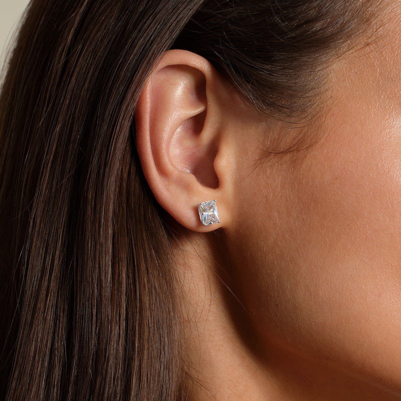 Close-up of model wearing emerald-cut cubic zirconia stud earrings in silver color