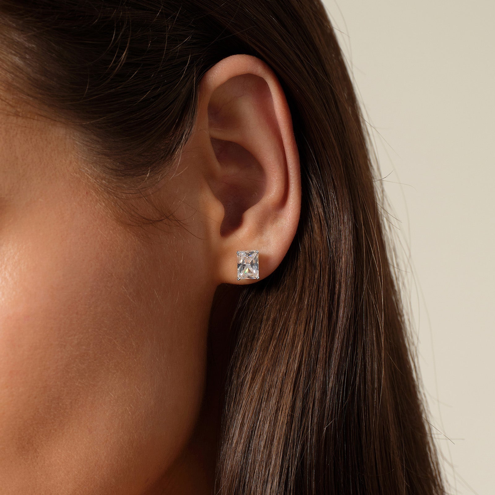 Model wearing emerald-cut cubic zirconia stud earrings in silver color