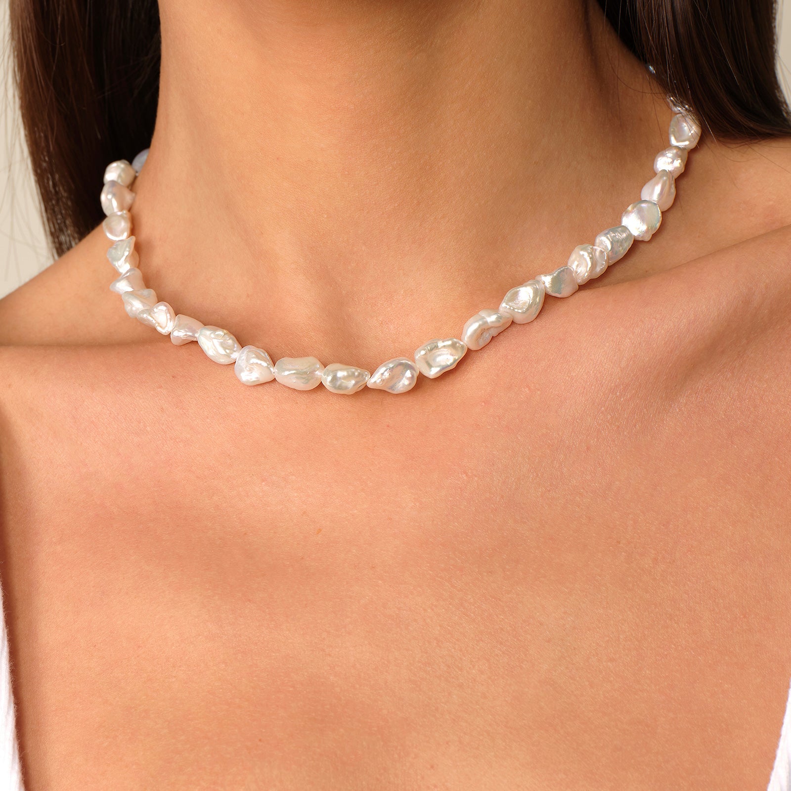 Model wearing a short freshwater Keshi pearl strand necklace at the collarbone