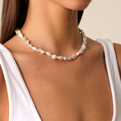 Model wearing a freshwater Keshi pearl strand necklace with a white top