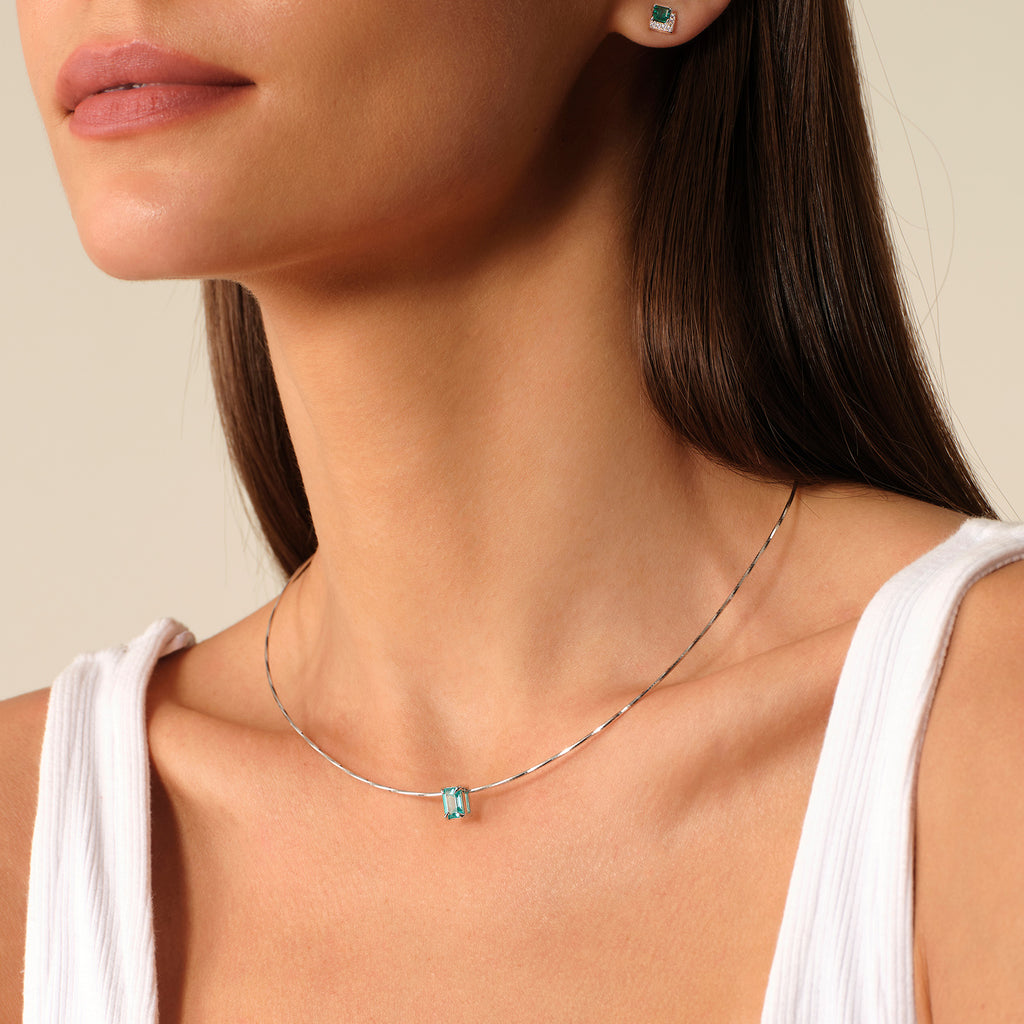Close-up of a model wearing a blue-green rectangular pendant necklace in sterling silver