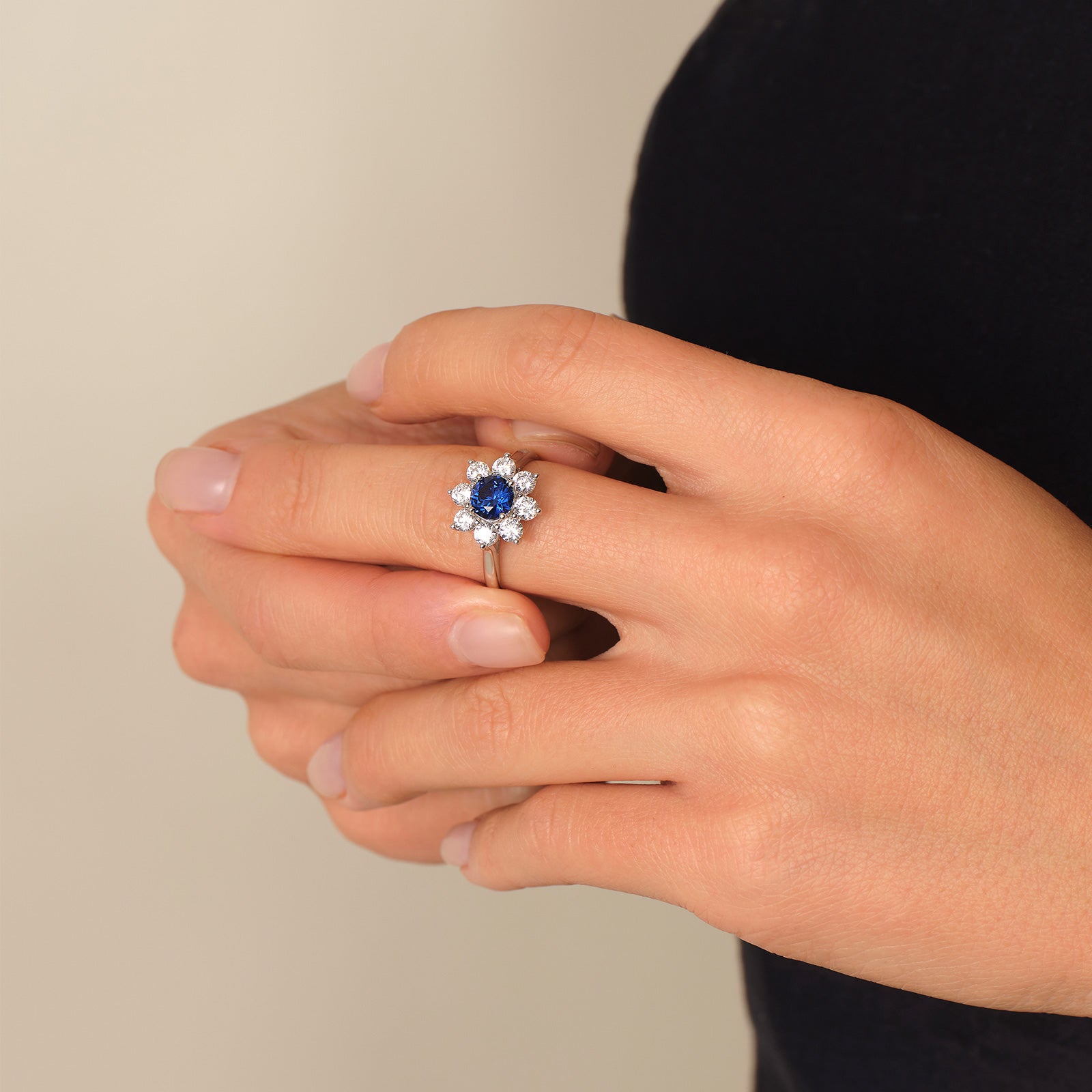 Model wearing a blue lab-created sapphire floral halo ring