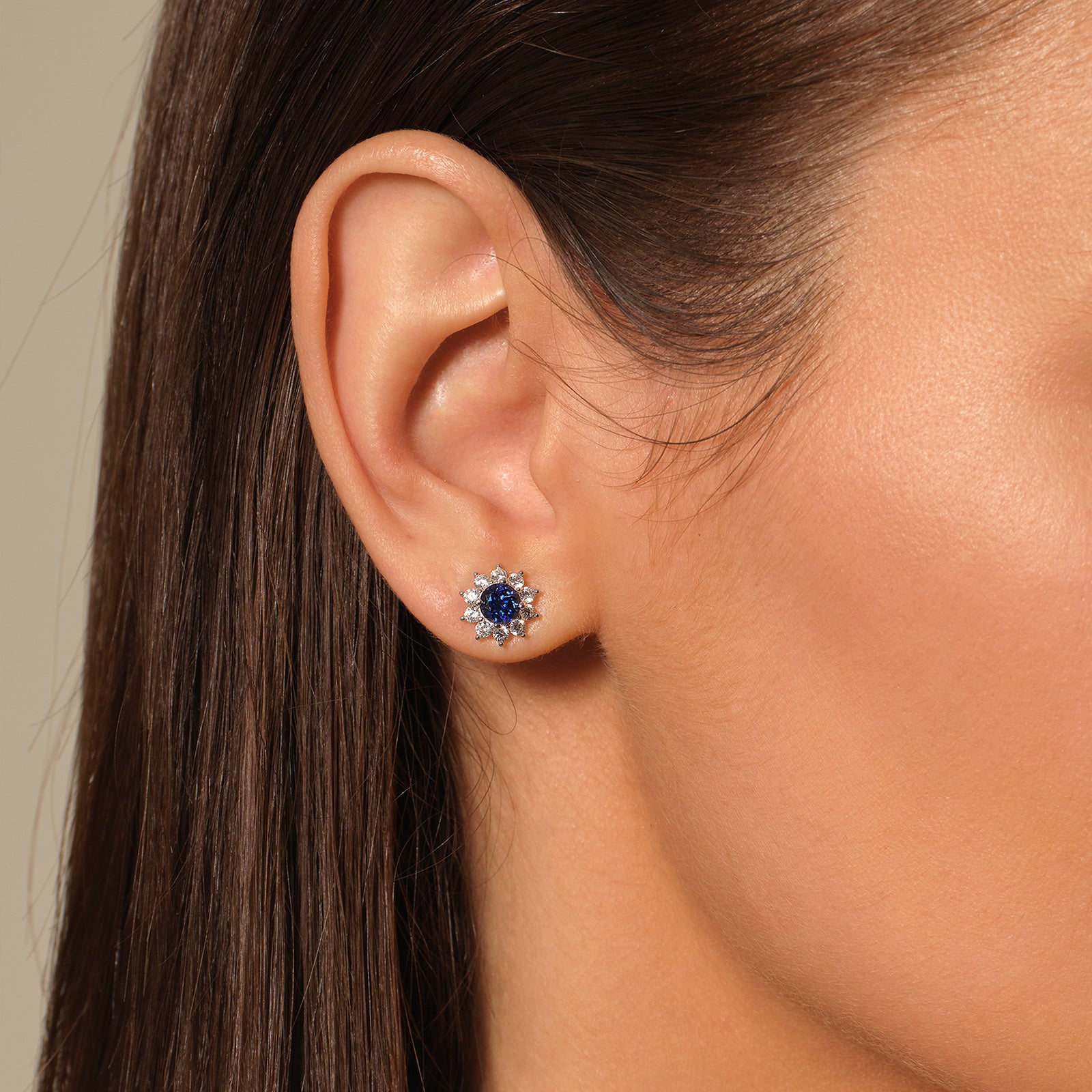 Model wearing a blue lab-created sapphire halo stud earring