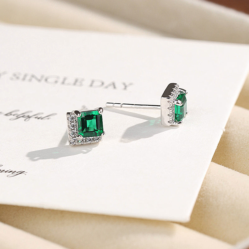 Square lab-grown emerald and cubic zirconia stud earrings shown on a card
