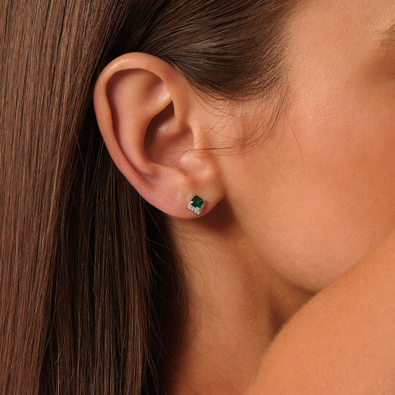 Side view of a model wearing a green lab-grown emerald stud earring