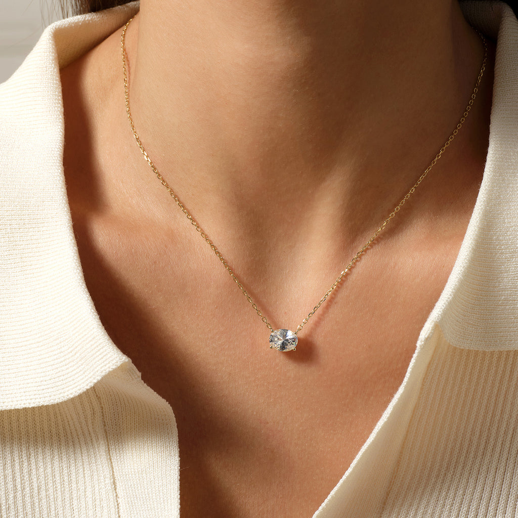 Model wearing oval cubic zirconia pendant necklace in yellow gold color