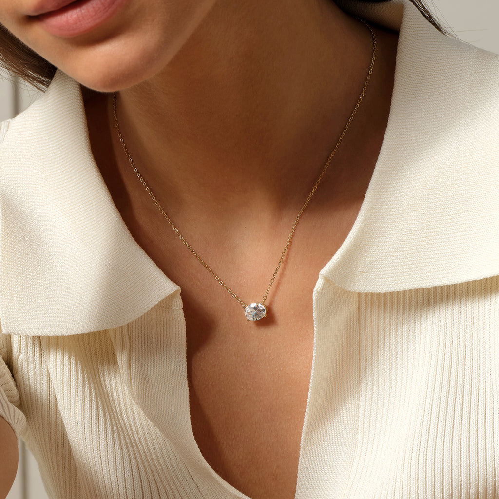 Model wearing oval cubic zirconia pendant necklace in yellow gold color, close view