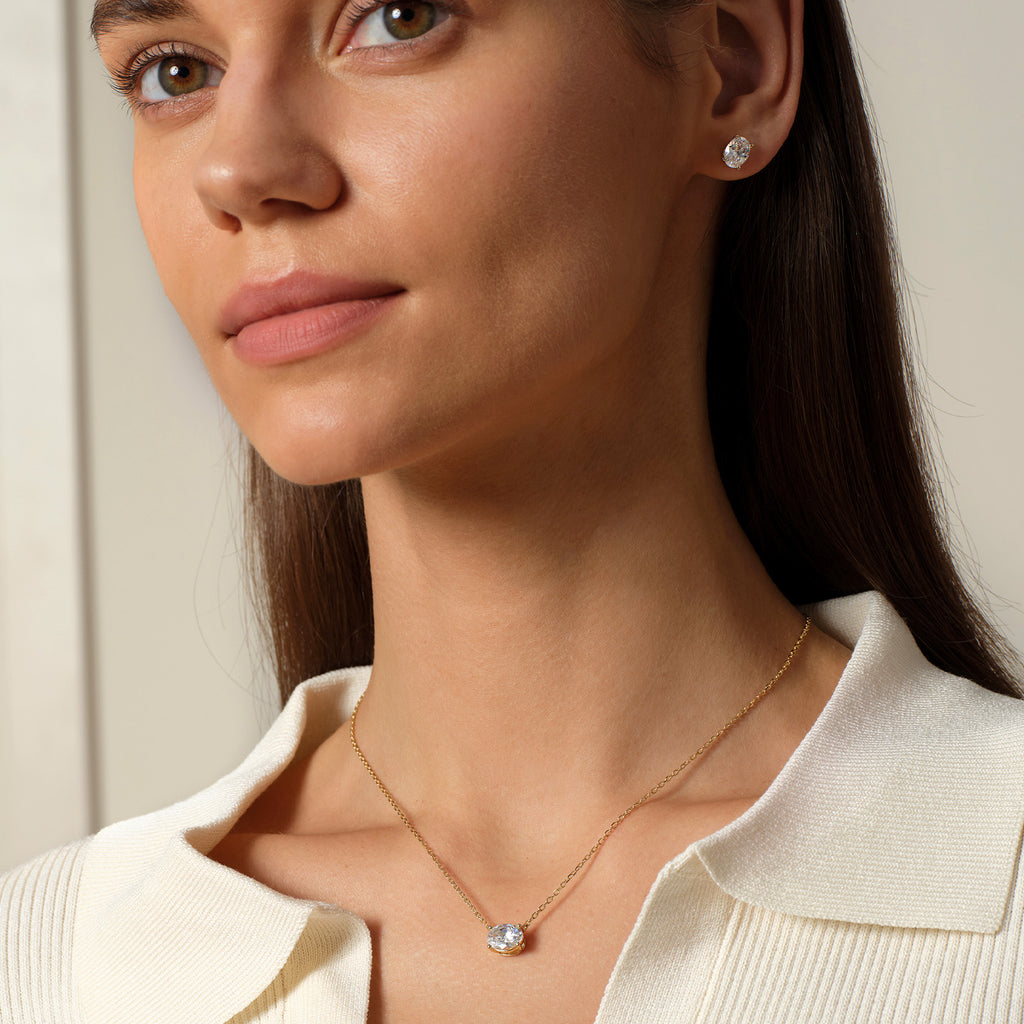 Model wearing oval cubic zirconia pendant necklace in yellow gold color, lifestyle view
