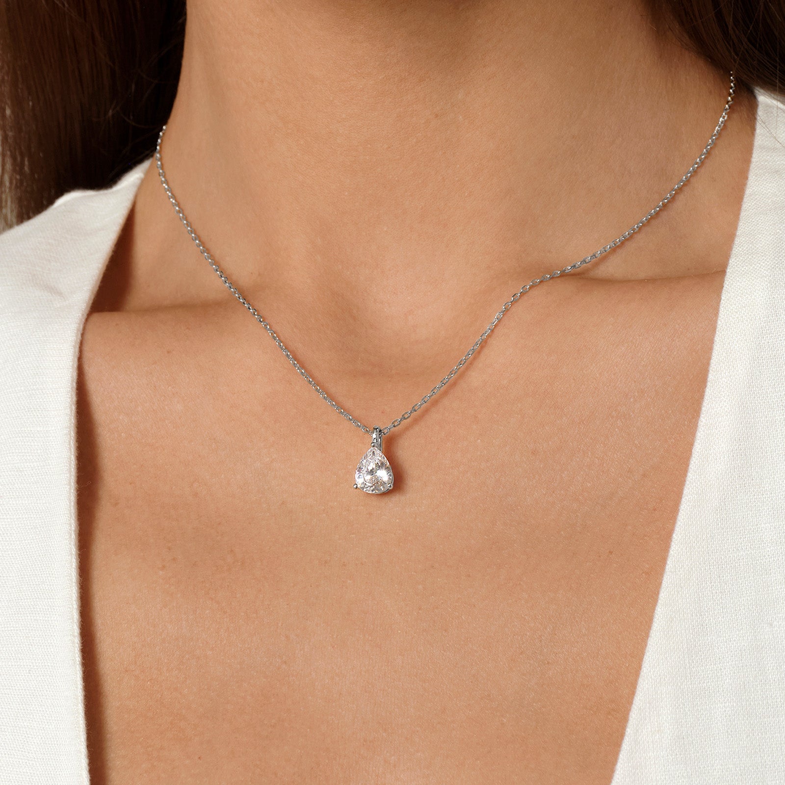 Model wearing pear-shaped cubic zirconia pendant necklace in white gold color