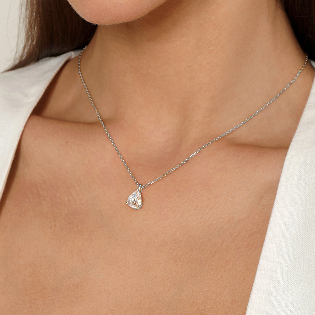 Model wearing pear-shaped cubic zirconia pendant necklace in white gold color, close view
