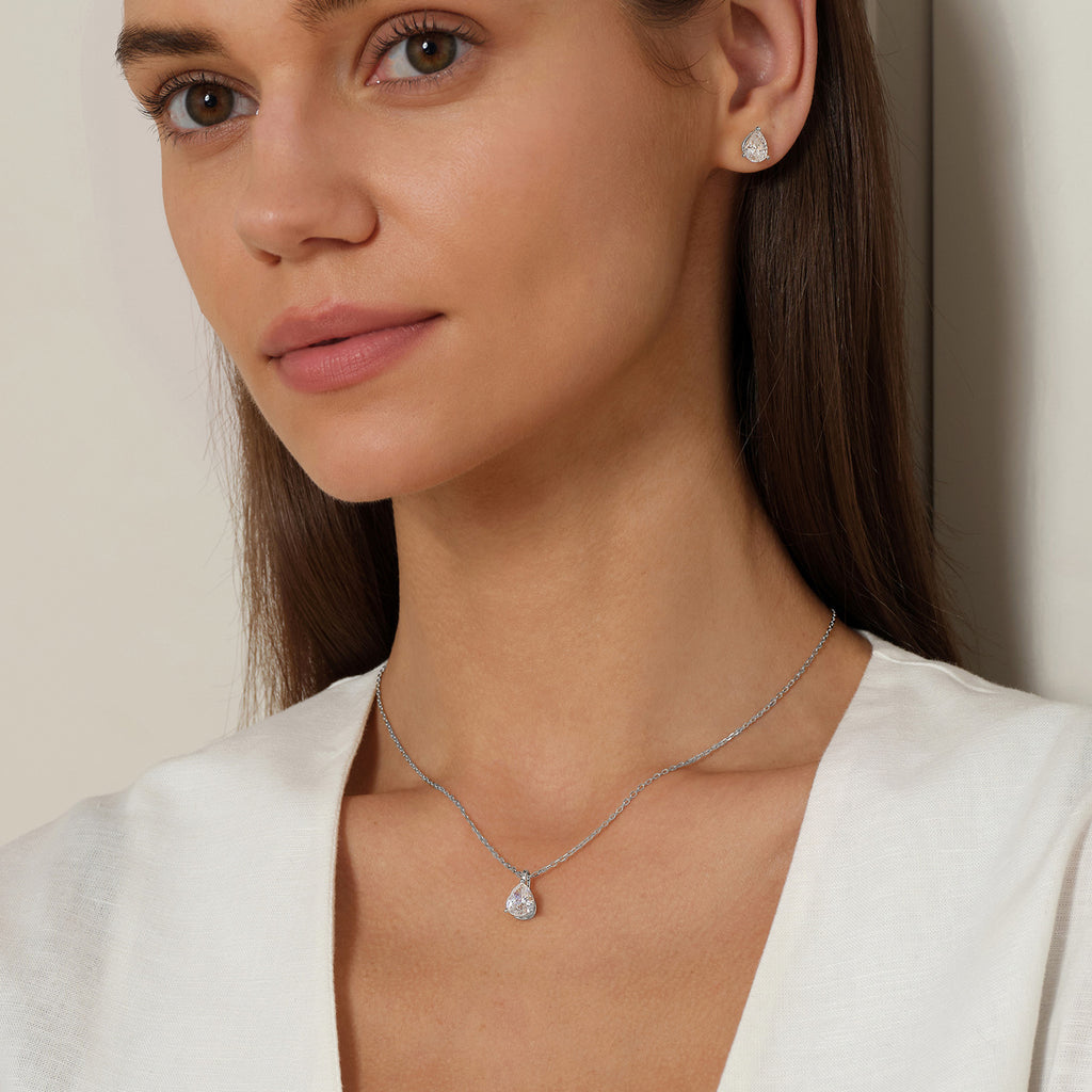 Model wearing pear-shaped cubic zirconia pendant necklace in white gold color with neutral outfit