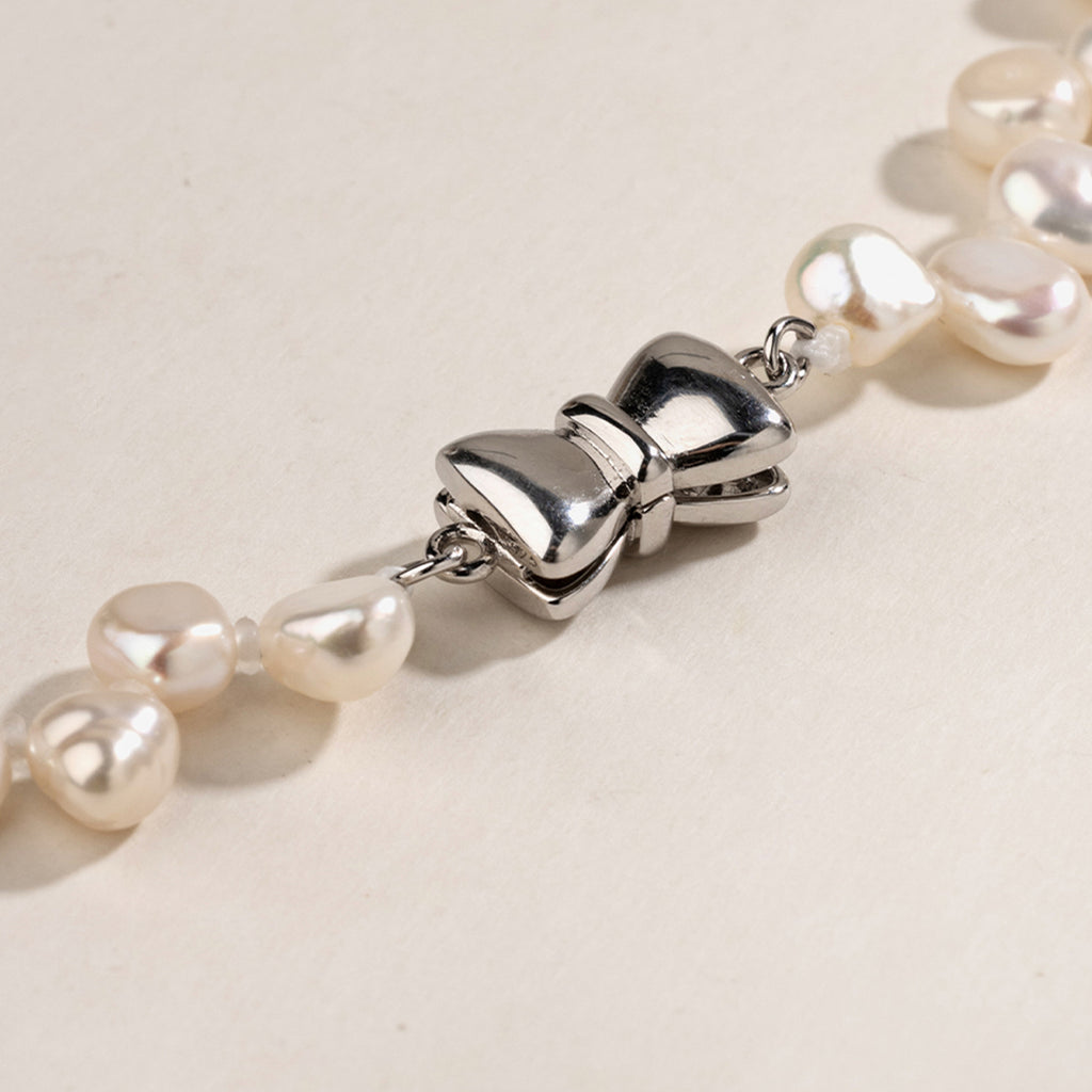 Freshwater pearl strand necklace styled in a lifestyle flat lay