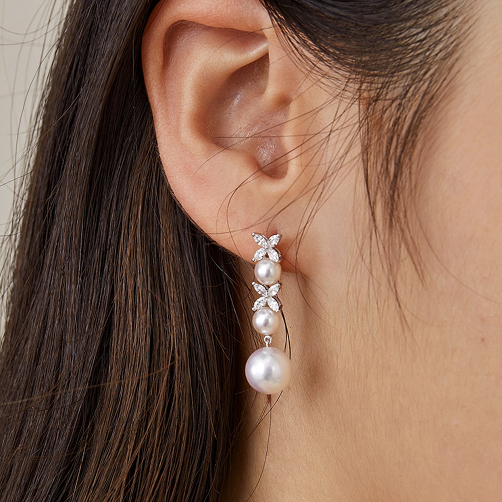 Model wearing freshwater pearl dangle earrings with hair tucked back