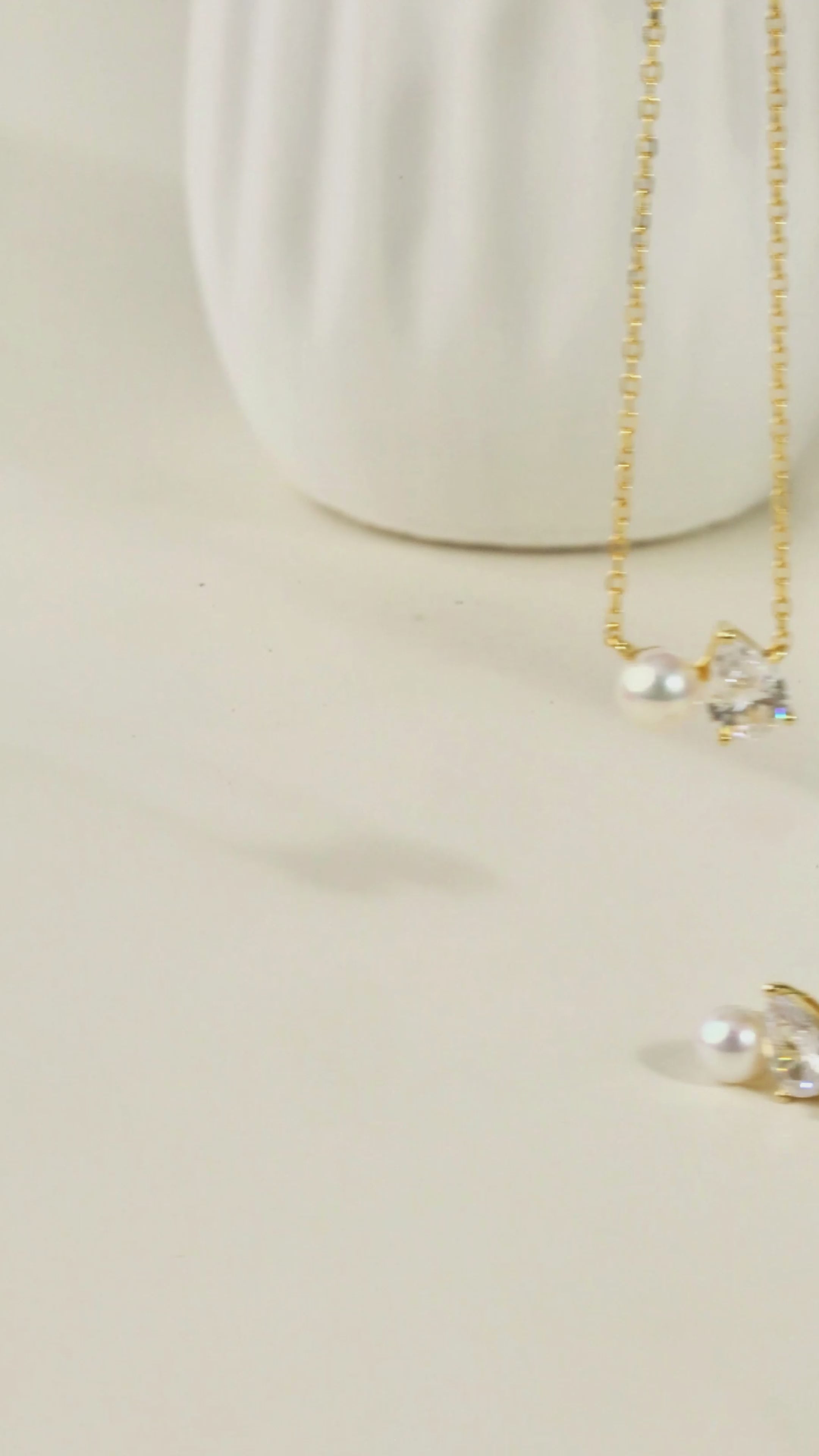 Product video for freshwater pearl and pear cubic zirconia stud earrings in yellow gold color