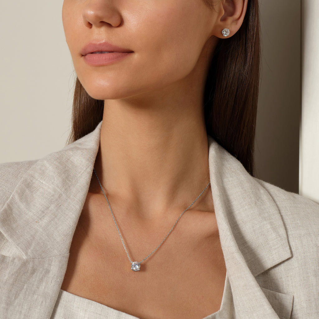 Model wearing round cubic zirconia solitaire pendant necklace in white gold color, lifestyle view